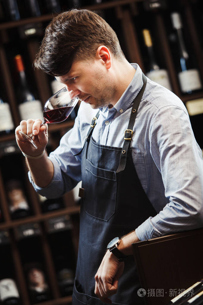 bokal 的背景下,男侍酒师欣赏喝红酒