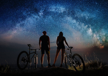 山地自行车在晚上在星空下与几个骑自行车的人