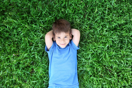 可爱的小男孩躺在草地上