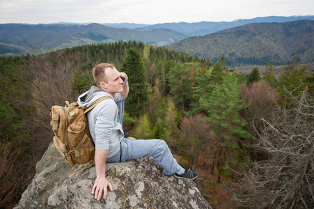 男性的攀援植物，具有棕色背包的岩峰上