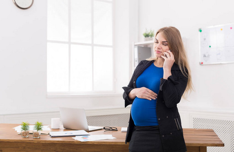 怀孕的商界女强人谈在办公室电话