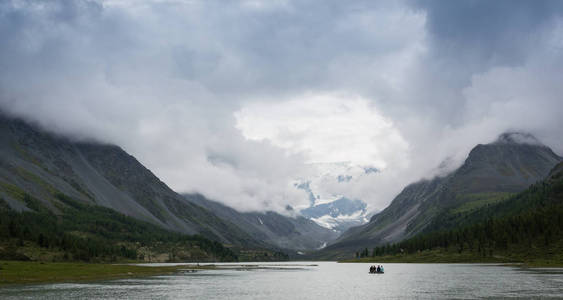 一群人在橡皮船游高山湖。俄罗斯阿尔泰山脉精神的湖