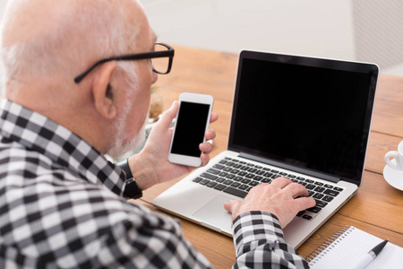 老人使用笔记本电脑和智能手机样机