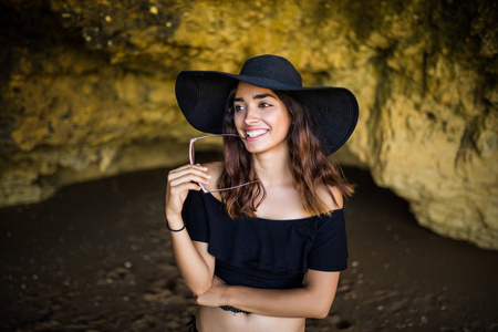 幸福美丽墨西哥女人帽子和太阳镜微笑附近的岩石海滩上夏天假期时间
