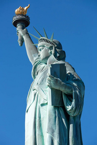 雕像的自由细节在阳光灿烂的日子，清除在纽约蓝蓝的天空