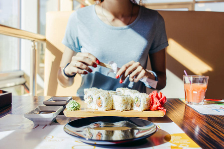 年轻女子在一家餐厅吃寿司照片
