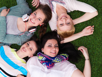 四名年轻女子躺在绿色的草地上