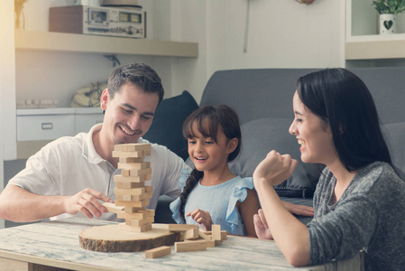幸福的家庭和女儿玩木积木塔在红磡