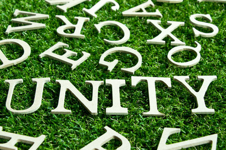 在人工绿草背景与英语字母表上的措词统一作为装饰