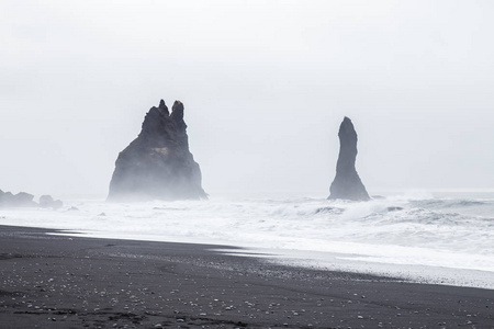 在 Dyrholaey，冰岛的黑沙海滩上美丽的火山岩石地层