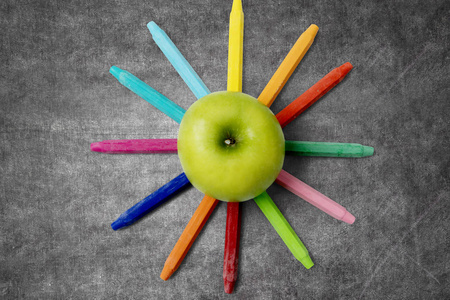 五彩的蜡笔，与绿色的苹果