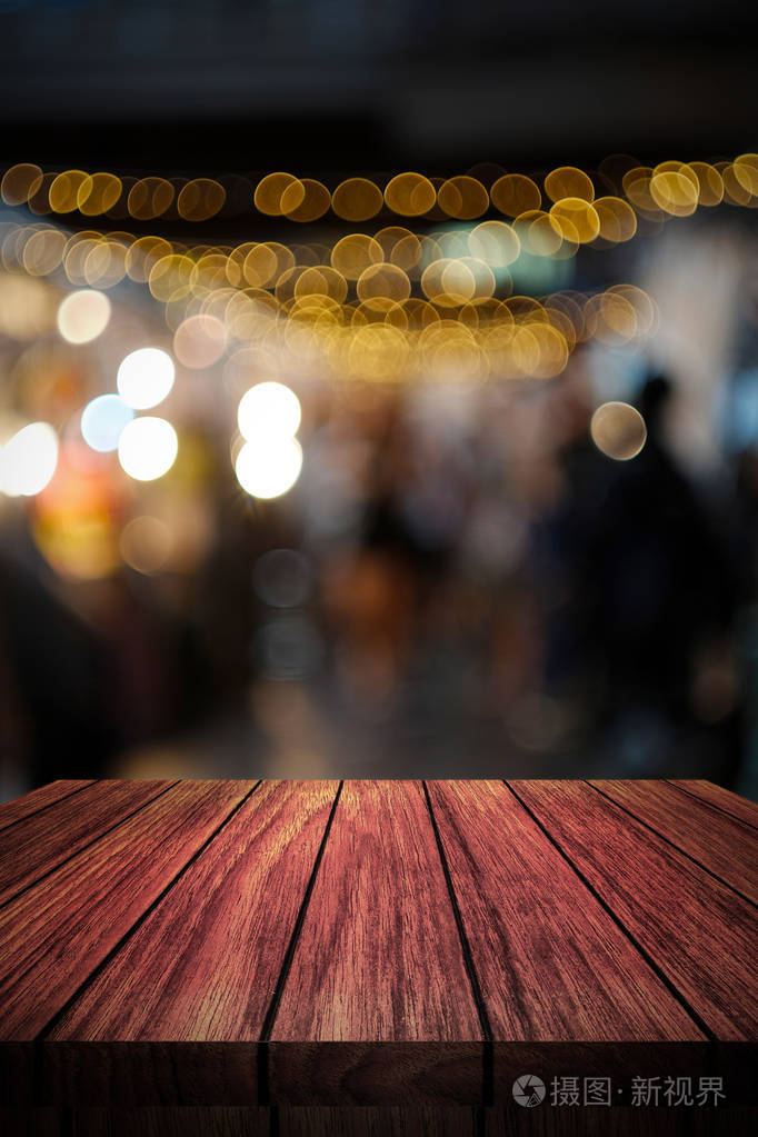 木桌在前面的抽象模糊背景灯