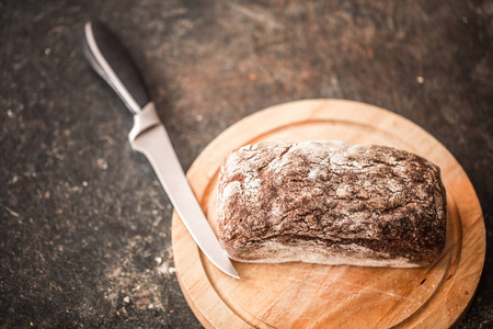 新鲜的面包，在手上老木背景特写