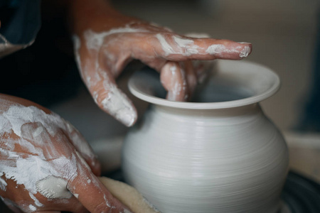 制陶工人工作在陶轮，肮脏的女人的手