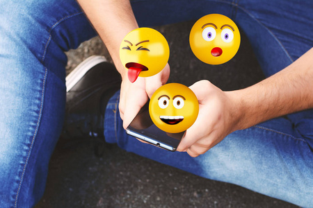 人使用智能手机发送 emojis