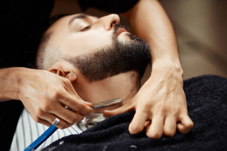 匿名男子剃须客户端男理发师的梳理和剃光头发的男性客户端皂洗和在
