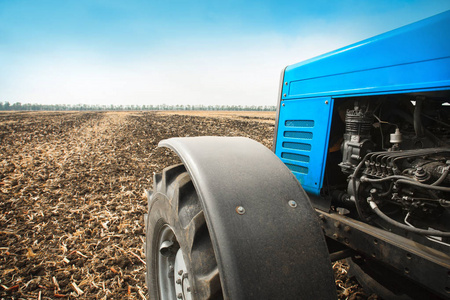旧的蓝色拖拉机特写空字段中。农业机械，实地工作