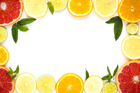 框架与橘子 柠檬 酸橙 葡萄柚和薄荷的模式，在白色的切片。平躺