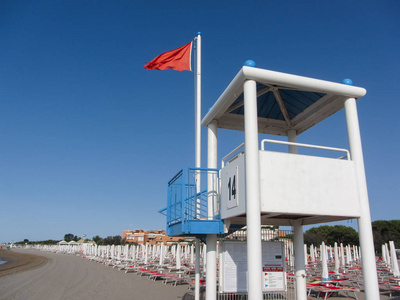 波涛汹涌的大海在救生员的红色标志塔长意大利海滩