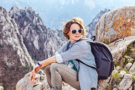 旅行者幸福的年轻女人在山上欣赏风景。F