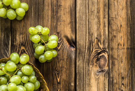 束绿色葡萄在篮子里，秋天的果实上木制背景