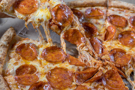 意大利辣香肠比萨饼上深色木制背景顶视图的腊肠。意大利传统食品
