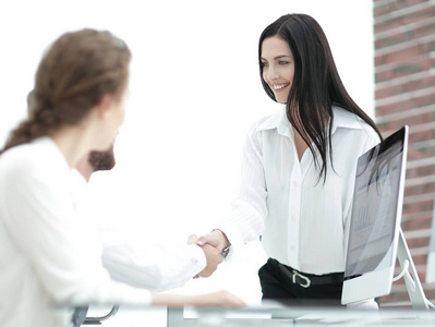 年轻的商界女人和一位同事握手