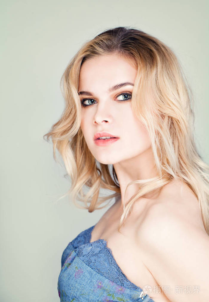 时尚的波浪形的头发可爱的金发女人的画像