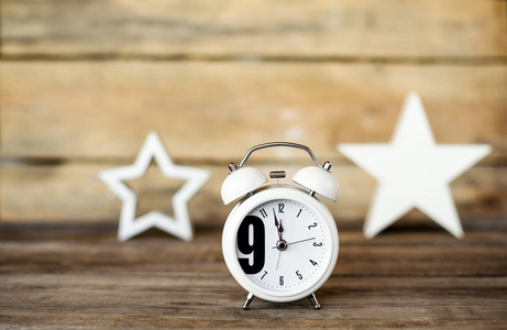 7 上午在早上八点钟的复古风格闹钟和玩具木制的桌子上的星星一样.
