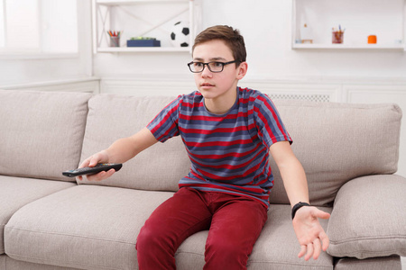 十几岁男孩看电视 使用远程控制