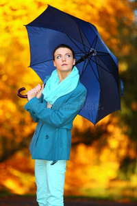 秋天公园里撑伞散步的小女孩
