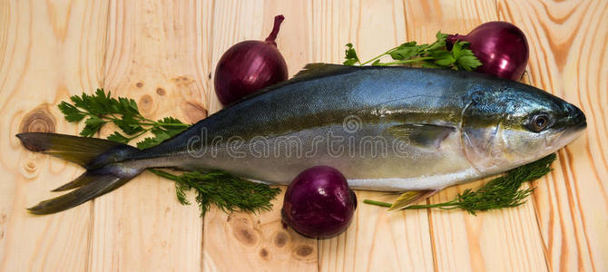 整条圆鱼黄尾和三个红洋葱照片
