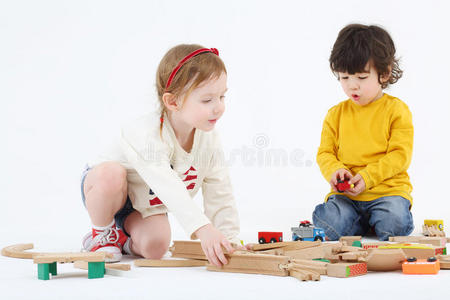 小男孩和小女孩用木制部件建造铁路
