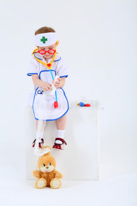 打扮成护士的小女孩给玩具兔子包头照片