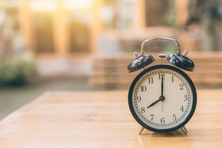 与绿色自然背景时间 8 上午上午的木桌上的时钟照片