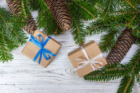 圣诞礼品盒上白色的木桌背景 云杉分支 松果 框架 顶视图，文本的空间