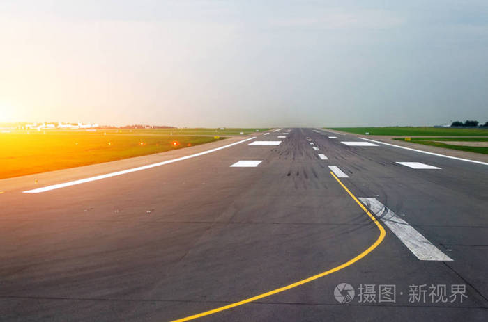 机场跑道飞机的清晨时分太阳早晨在橡胶轮胎痕迹与眩光