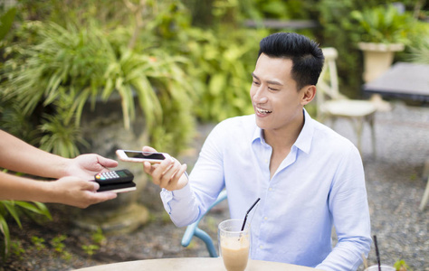 男人付钱给条例草案通过智能手机使用中餐馆的 Nfc 技术