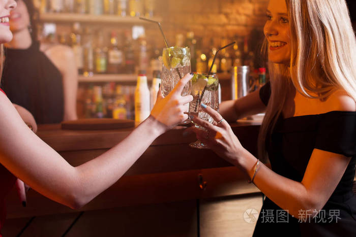 有晚上出去举杯同莫吉托鸡尾酒在酒吧的两个女友