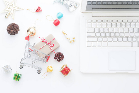 圣诞装饰品和礼品盒购物车和笔记本电脑，在线购物概念顶视图