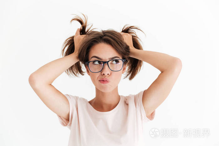 沉思的漂亮女人,在眼镜抓着头发,看着别处