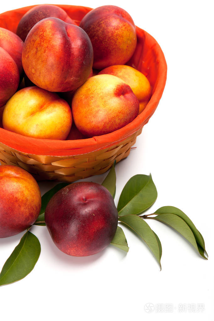新鲜水果油桃在篮子里在白色背景上