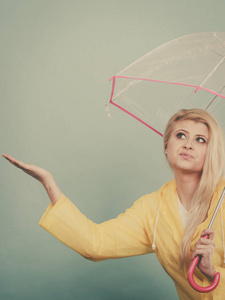 女人穿着雨衣打着伞检查天气图片