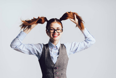 与眼镜笑的女孩老师让自己为白色背景上的马尾辫照片
