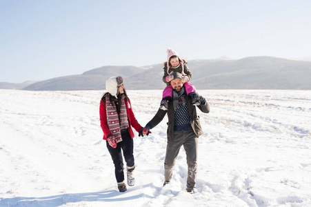 父亲和母亲带着他们去散步，冬天自然的女儿