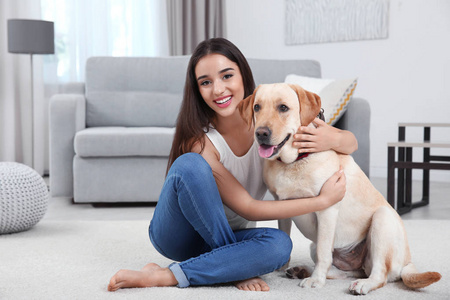 年轻女子和黄色猎犬在家休息