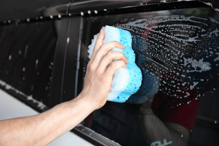 男人洗窗的汽车用海绵，特写