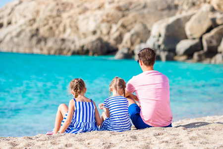 爸爸和孩子在欧洲海岸的白色沙滩上的家庭