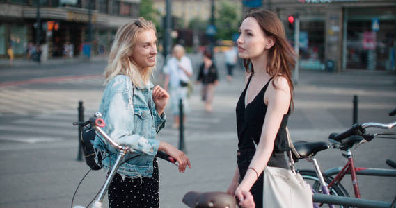 两个活泼的女孩在一个城市里谈论最新的八卦新闻
