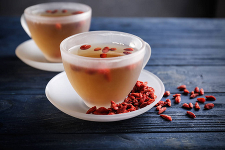 枸杞茶在桌子上的杯子照片